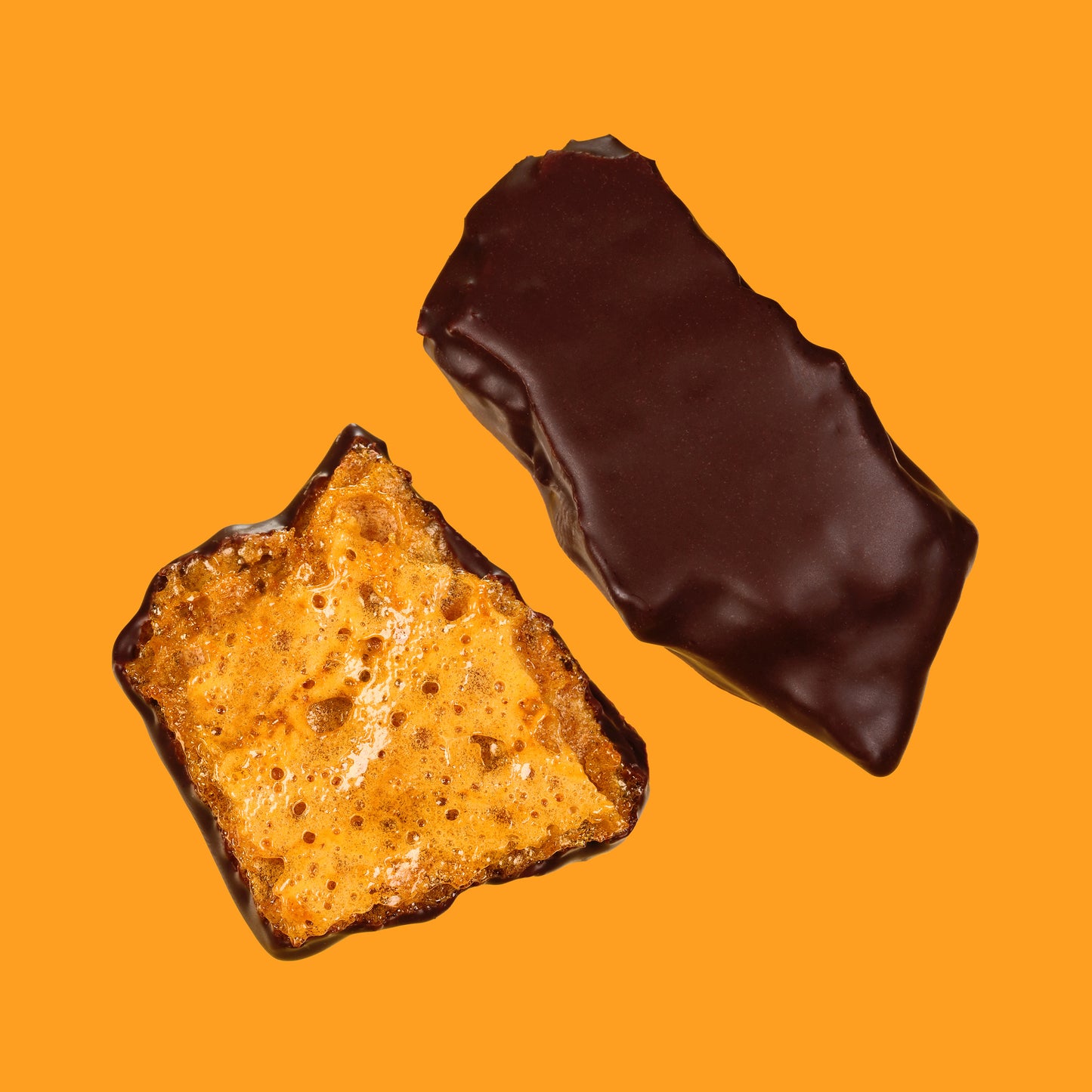 Two chocolate-dipped snacks on an orange background