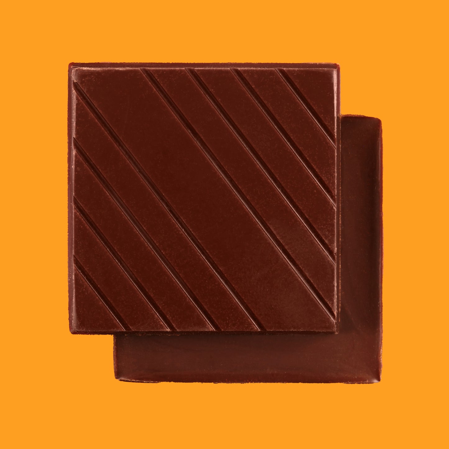 Stack of dark chocolate bars using cocoa beans from Tsiriari, Peru on an orange background