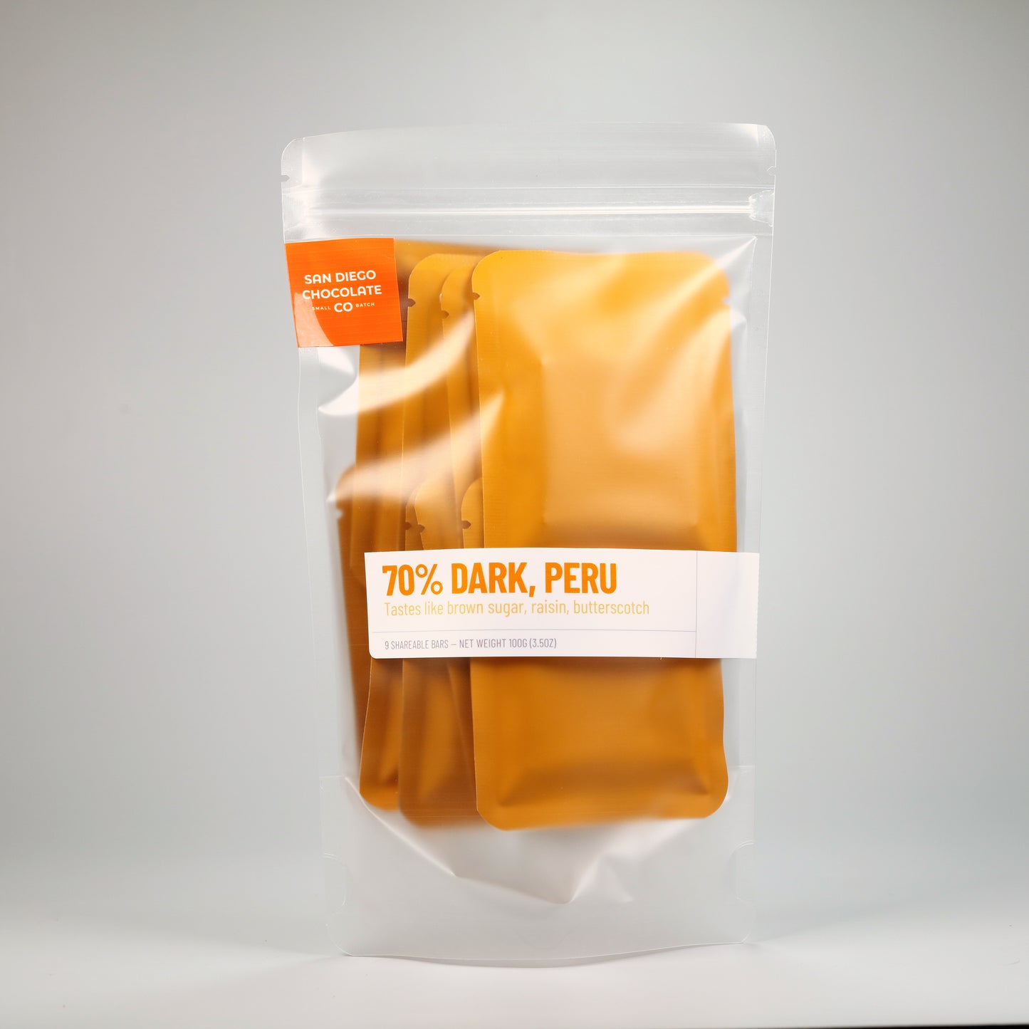 Bag of of 70% Dark Peru chocolate bars, individually wrapped in golden yellow with a white background. 
