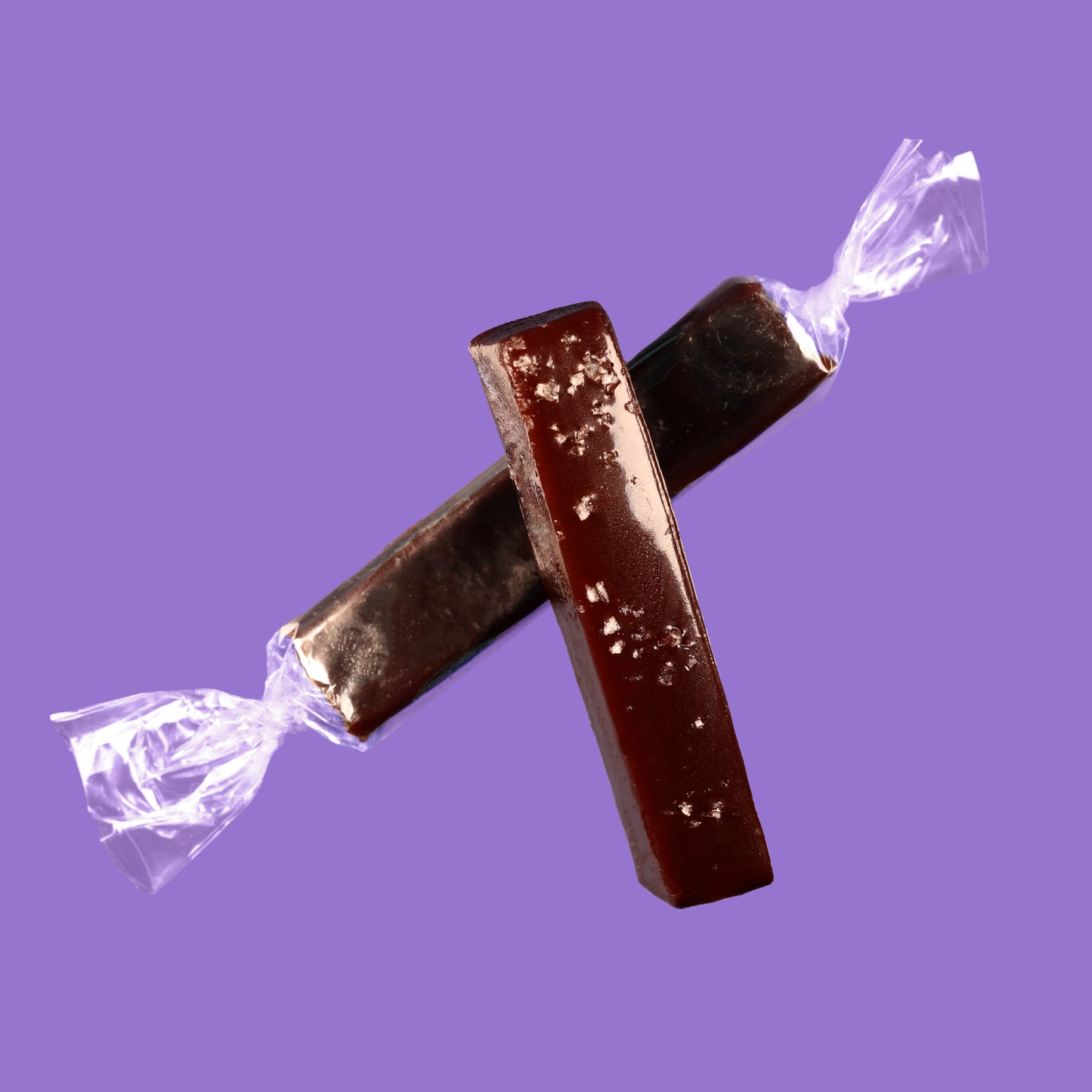 Top down view of a wrapped and unwrapped dark chocolate sea salt caramel.