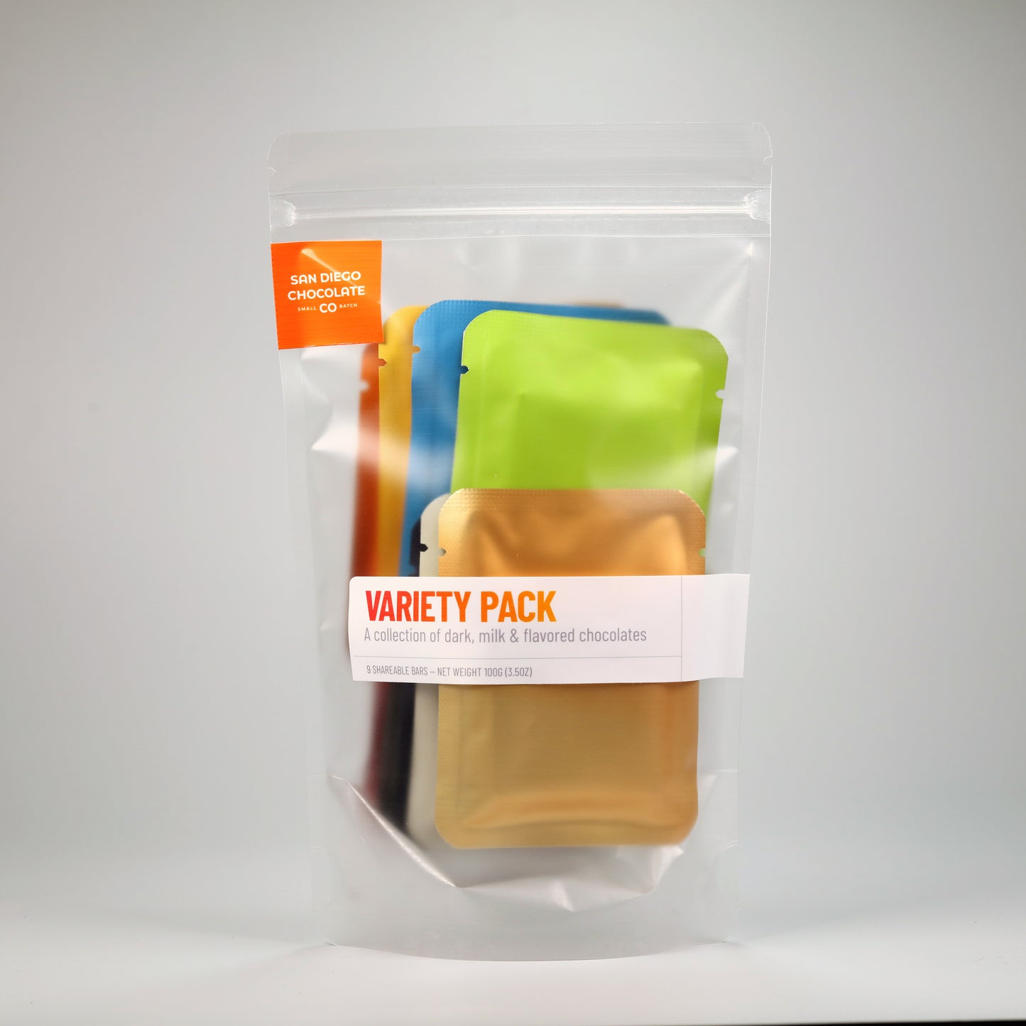 Packaged variety pack of chocolates with colorful sachets on a white background