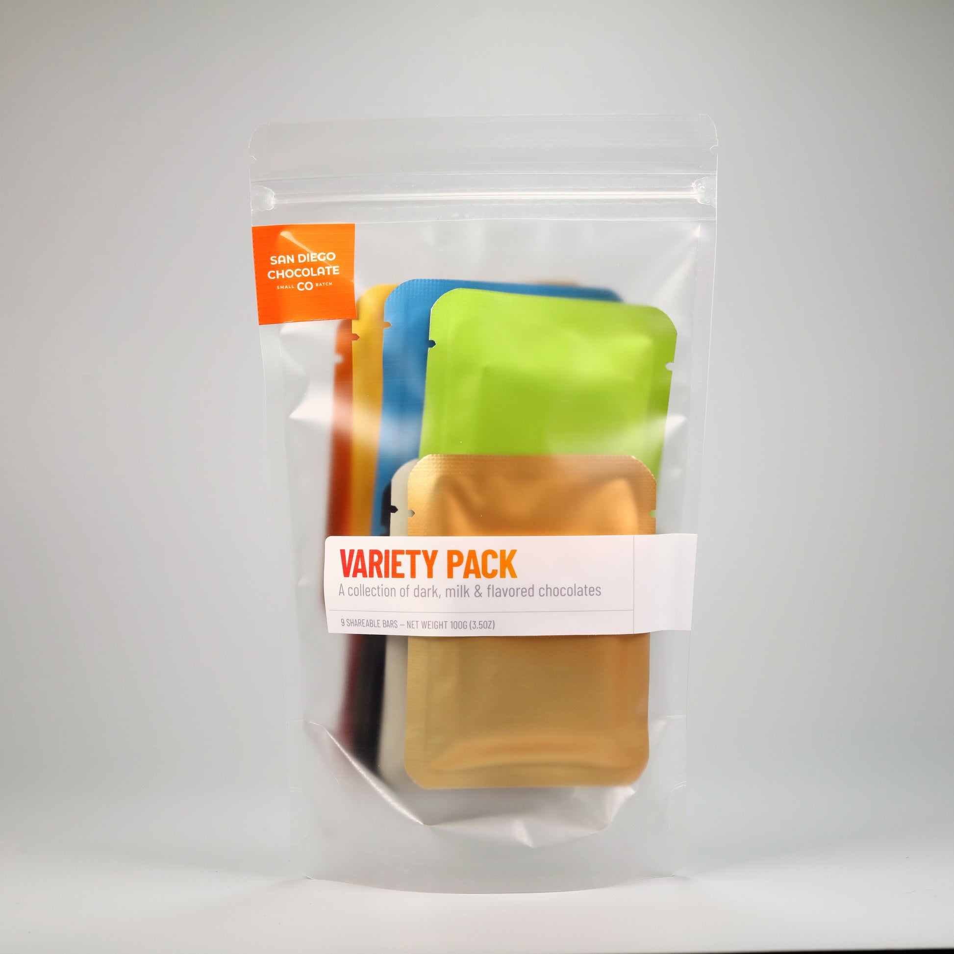 Packaged variety pack of chocolates with colorful sachets on a white background